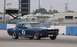 1965 Ford Mustang - A blue 1965 Ford Mustang race car with white stripes and the number 2 on its door is seen on the track.