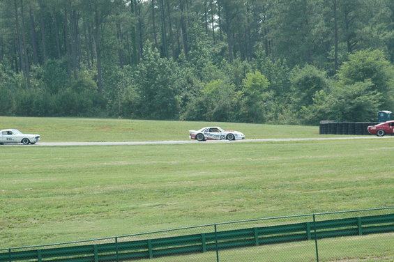 White race car with number 65 and 'Motorcraft' livery, side view