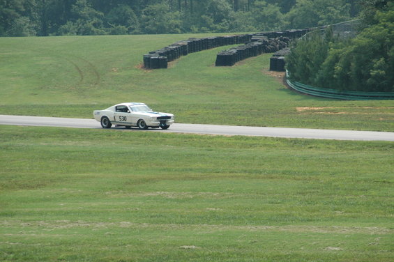 White 1967 Ford Mustang race car with number 530 on the door, driving on a track
