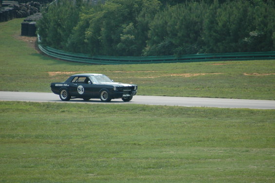 Dark coupe with white stripes and number 84 on door, side view