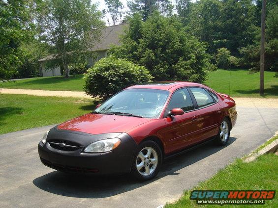 Red 2001 Ford Taurus with a black car bra parked on a driveway