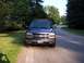 2002 Chevrolet Suburban - A dark gray Chevrolet SUV is parked on the side of a road in a suburban neighborhood.