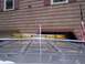 2002 Chevrolet Suburban - The top of a gray SUV is visible, equipped with a yellow light bar and an antenna, parked in front of a house.