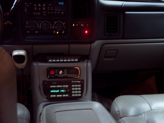 Interior shot of a vehicle's center console, showing multiple radios and a microphone
