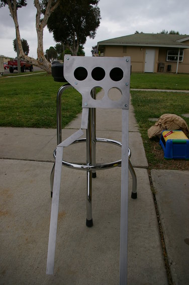 Aluminum bracket with six circular holes, mounted on a chrome stool