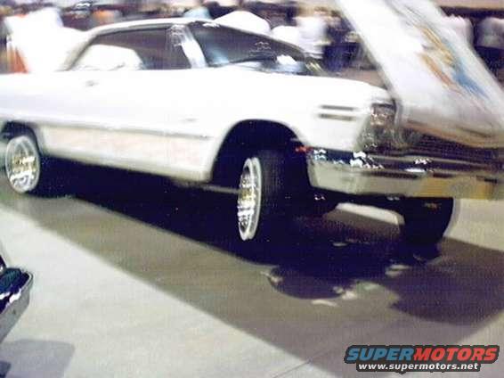 White 1964 Chevrolet Impala with hood open, chrome grille, and custom wheels