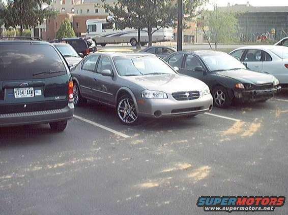 Silver sedan with custom rims parked in a lot, front quarter view