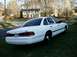1996 Ford Crown Victoria - White 1995 Ford Crown Victoria seen from the rear quarter angle, parked on a grassy lawn.