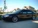 2000 Ford Taurus - This black sedan is parked in front of a suburban house. It has custom wheels and tinted windows.