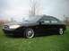 2000 Ford Taurus - A black 2000 Ford Taurus sedan with custom chrome wheels is shown from a three-quarter front view.