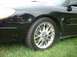 2000 Ford Taurus - Close-up of a black car's front fender and chrome wheel.