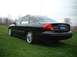 2000 Ford Taurus - A black 2000 Ford Taurus is parked on a grassy field with trees in the background.