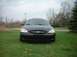 2000 Ford Taurus - A black 2000 Ford Taurus is shown from the front, parked in a grassy area with trees in the background.