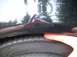 2000 Ford Taurus - A hand presses on the tire of a black 2000 Ford Taurus, showing the wheel well gap.