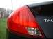 2000 Ford Taurus - The rear of a black sedan is shown with a prominent red taillight and partial badging.