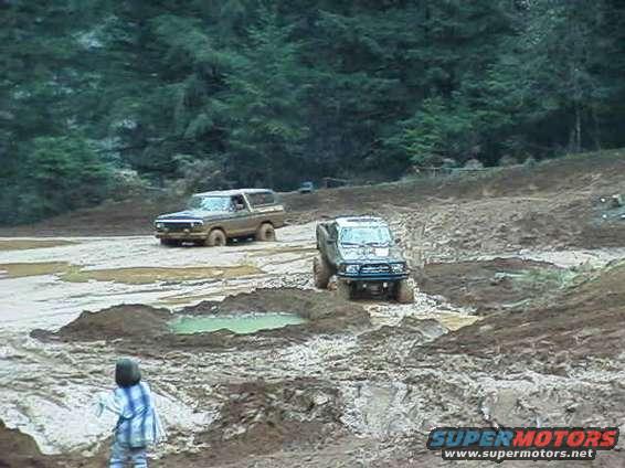 1978 Ford Bronco and another off-road vehicle in mud