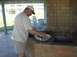 1996 Ford Bronco - A man prepares food at an outdoor brick grill, with a sink and a visible Supermotors.net watermark from 2002.