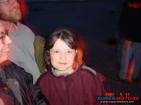 People gathered outdoors at night, with a date stamp of 2002