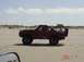 1996 Ford Bronco - This red Ford Bronco is seen on the beach with passengers in the open rear.