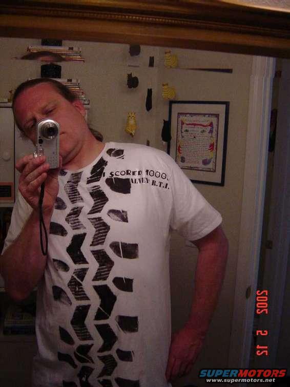 Man in tire tread t-shirt takes selfie in mirror