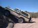 1979 Ford Bronco - This Ford Bronco is navigating a steep, rocky trail under a clear blue sky.