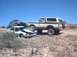 1979 Ford Bronco - A classic Ford Bronco is positioned over a crushed sedan in a desert landscape.