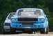 1965 Ford Mustang - A blue 1965 Ford Mustang race car is seen from the front, with another vehicle behind it on the track.