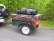 1991 Ford Bronco - A trailer loaded with camping gear is towed by a vehicle, which has a spare tire with a "FORD" label.