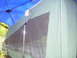 1991 Ford Bronco - A tent trailer is set up outdoors under a blue canopy, with a view through its mesh window.