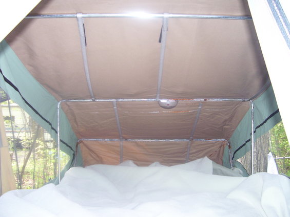 Interior view of a pop-up camper tent with metal frame and tan fabric