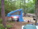 1991 Ford Bronco - A campsite scene with a vehicle and an attached pop-up tent, set up among trees.