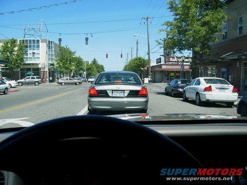 Rear view of a 1998 Ford Crown Victoria in traffic, with a white Volvo S60 ahead