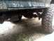 1996 Ford Bronco - The underside of a muddy 4x4 shows its suspension and large off-road tire.
