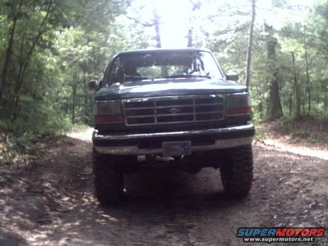 Green 1996 Ford Bronco front view on a dirt road