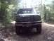 1996 Ford Bronco - A green 1996 Ford Bronco is seen from the front on a wooded dirt road.