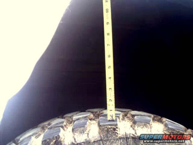 measuring tire tread depth with a yellow ruler