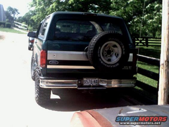 Rear view of a lifted 1996 Ford Bronco in green with a spare tire mounted externally