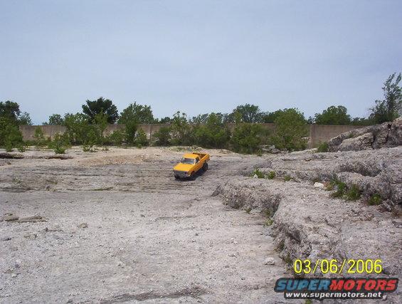 Yellow pickup truck in a rocky, outdoor scene