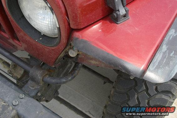 Red 1998 Jeep TJ front fender and headlight detail