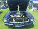 1965 Ford Mustang - A 1965 Ford Mustang is displayed with its hood open, a trophy in the engine bay.