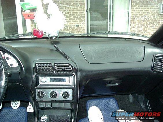 Dashboard of a 1995 Ford Probe, showing the center console with radio and climate controls, air vents, and a portion of the steering wheel