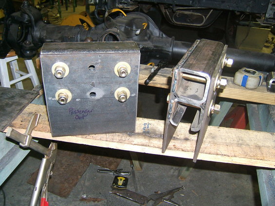 Two custom metal suspension brackets with bolts and nuts, one labeled 'Passenger Out'