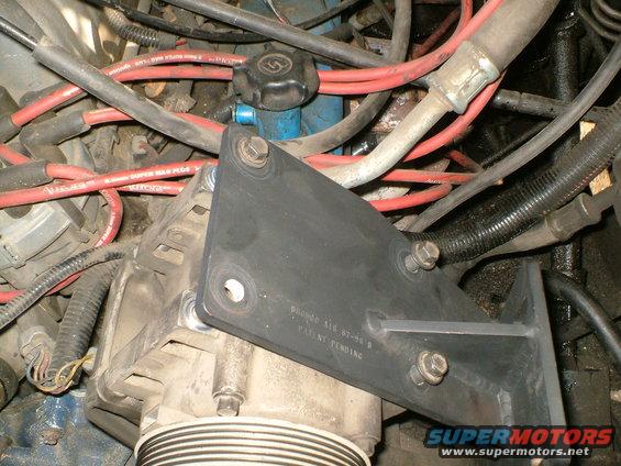 Engine bay with alternator and red spark plug wires. Black bracket has text 'BRONCO 416 87-96 B PATENT PENDING'