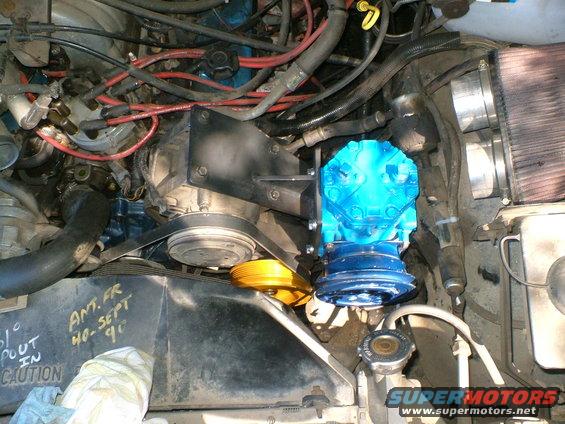 Engine bay with blue compressor and yellow pulley. Text on radiator support reads 'ANT. FR 40-SEPT 90'