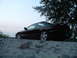 1995 Ford Probe - A black 1995 Ford Probe is parked on a gravel lot under a large tree during twilight.