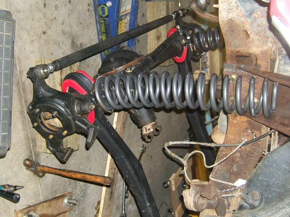 Ford Bronco front suspension components, including springs, shocks, and steering linkage, laid out in a workshop