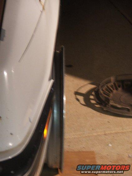 White car fender and tire with a chrome rim, side view