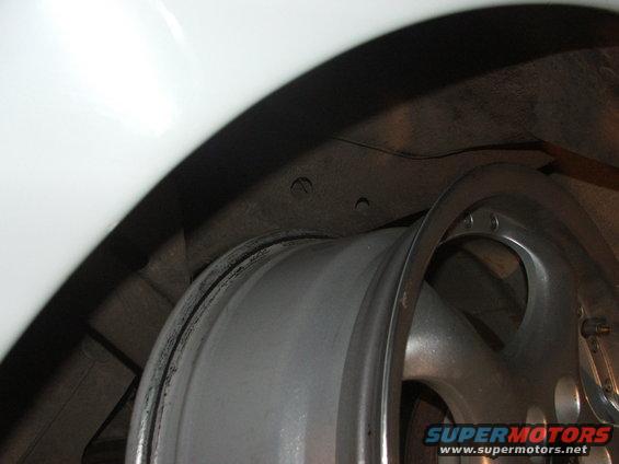 Close-up of a silver alloy wheel and white fender liner