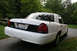 2003 Ford Crown Victoria - Rear view of a white 2003 Ford Crown Victoria, parked outdoors.