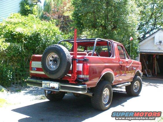 Red 1989 Ford Bronco rear view with spare tire and Hi-Lift jack